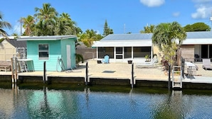 A waterfront property with a dock, a small shed, and a covered outdoor seating area. - Waterfront Marathon FL Keys Home w/ Private Dock (Marathon)