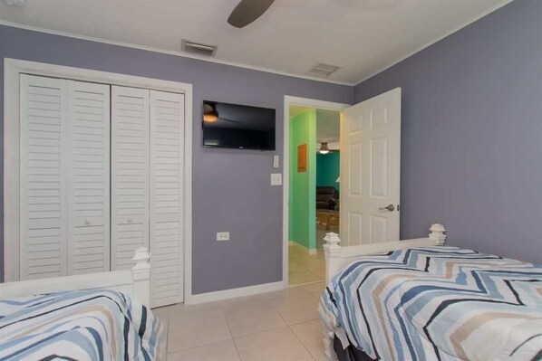 A bedroom with two beds, a TV, and a closet. - Waterfront Marathon FL Keys Home w/ Private Dock (Marathon)