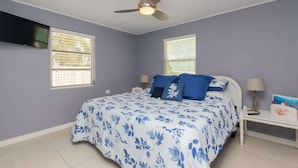 A bedroom with a bed, two nightstands, a ceiling fan, and two windows with blinds. - Waterfront Marathon FL Keys Home w/ Private Dock (Marathon)