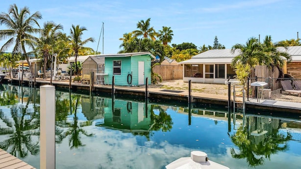 A marina with a calm water body, small houses, and palm trees. - Waterfront Marathon FL Keys Home w/ Private Dock (Marathon)