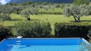 A swimming pool with a view of a green landscape and mountains in the background.