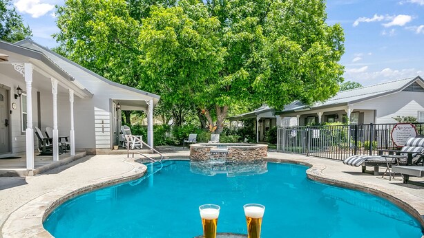 A swimming pool with lounge chairs and a covered seating area.