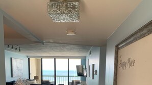 Un pasillo con vistas al mar, un candelabro y un letrero que dice 'Happy Place'.