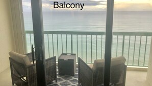 Un balcón con muebles de mimbre y vistas al mar.