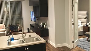 A modern kitchen with a built-in island, dark cabinetry, and a large window with blinds.