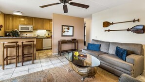 Une cuisine moderne avec des meubles en bois, un four à micro-ondes et un ventilateur de plafond.