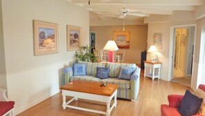 A living room with a wooden coffee table, striped sofa, and two lamps.