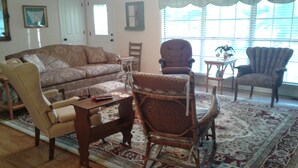 A living room with a patterned sofa, a wooden coffee table, and two armchairs. - Comfort and Chickens (Clarksville)