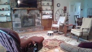 A cozy living room with a fireplace, a television, and comfortable seating. - Comfort and Chickens (Clarksville)