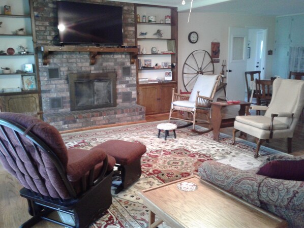 A cozy living room with a fireplace, a television, and comfortable seating.