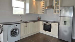 A modern kitchen with a built-in washer, oven, and stainless steel refrigerator.