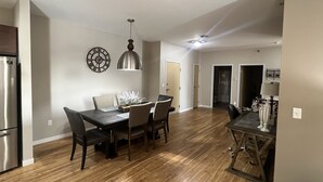 Cozinha espaçosa com área de jantar, piso de madeira e eletrodomésticos modernos.