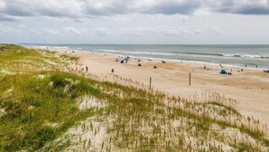 A beach with dunes, people, and tents. - Perfectly pool side at APATB! King, Full, 2 Twins (Atlantic Beach)