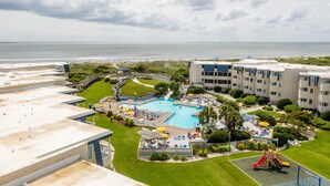 A resort with a large pool, a playground, and a beach view. - Perfectly pool side at APATB! King, Full, 2 Twins (Atlantic Beach)