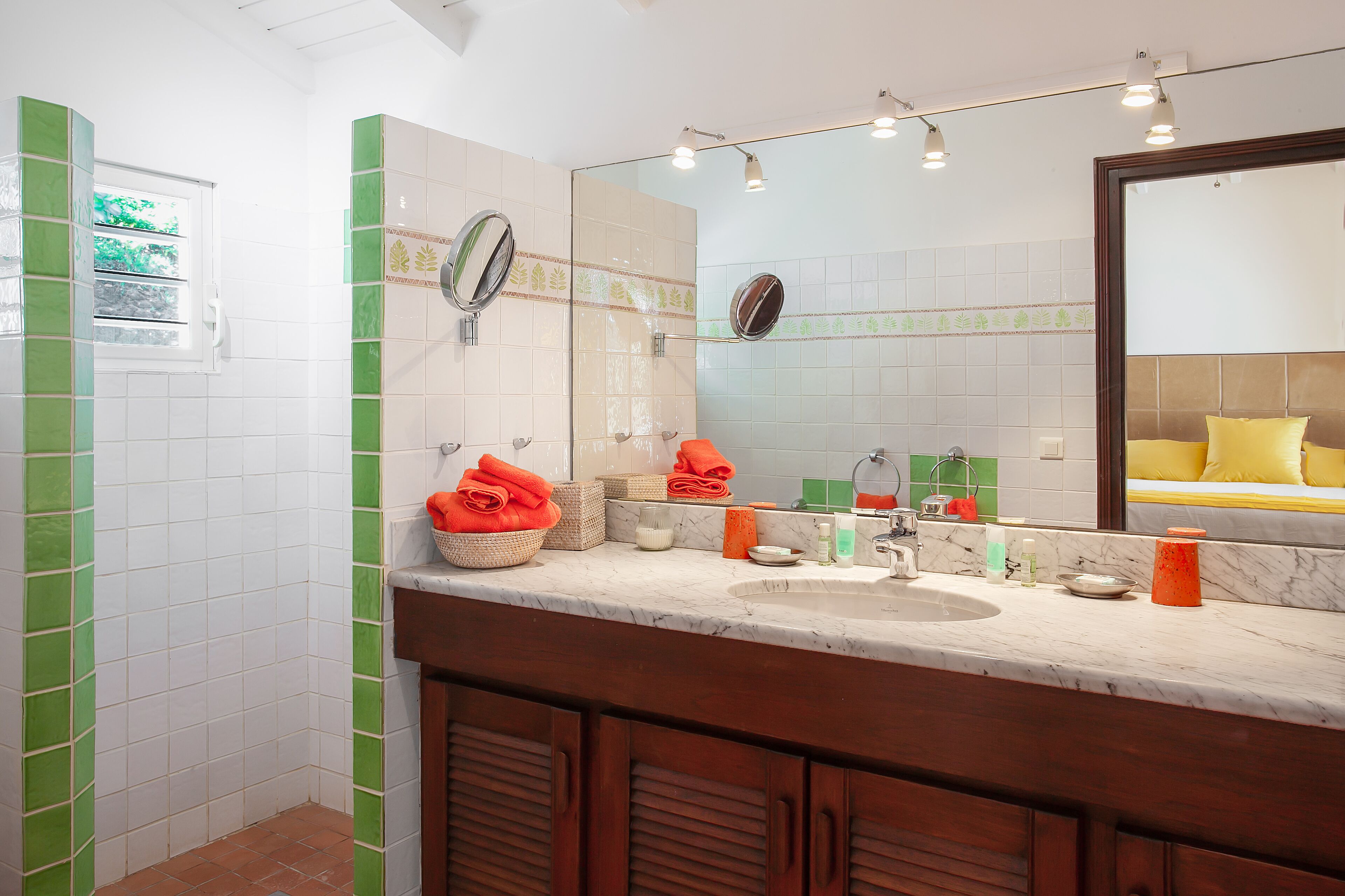 A bathroom with a sink, mirror, and toiletries.