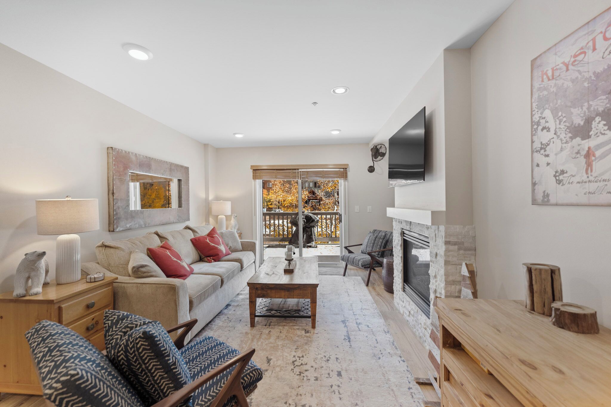 A modern living room with a sofa, armchairs, a coffee table, and a fireplace.