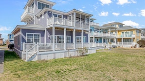 A multi-story beachfront house with a balcony, a covered porch, and a grassy yard. - Only 1 Block to the Beach - Community Pool - Featured on HGTV!  (Cape Charles)