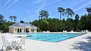 A swimming pool with lounge chairs and a small building, surrounded by trees. - Only 1 Block to the Beach - Community Pool - Featured on HGTV!  (Cape Charles)