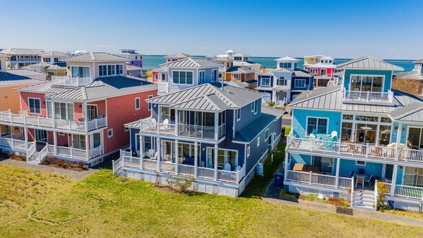 A coastal residential area with multi-story houses featuring balconies, large windows, and a clear view of the sea. - Only 1 Block to the Beach - Community Pool - Featured on HGTV!  (Cape Charles)