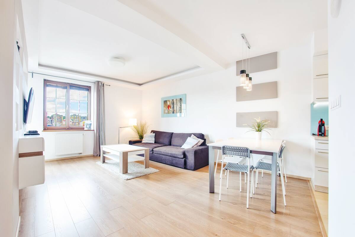 Una sala de estar moderna con sofá, mesa de centro y comedor.
