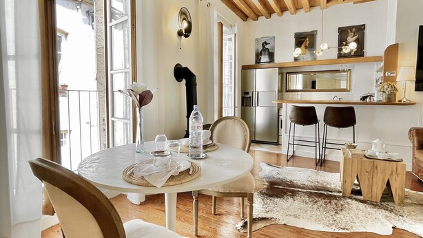 Comedor con mesa redonda, sillas y techo de madera.