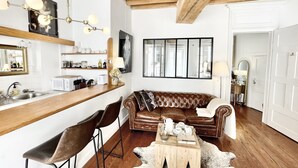 Una cocina moderna con encimera de madera, un comedor con sofá de cuero marrón y una mesa de centro de madera.