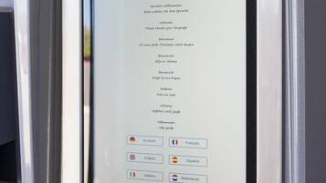 A self-service kiosk with a screen displaying language options for a motel.