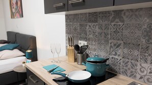 A modern kitchen with a wooden countertop, a blue pot, a frying pan, and a sink. - Motel24seven (Bruck an der Mur)