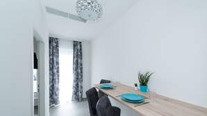 A modern dining area with a wooden table, black chairs, and a potted plant. - Motel24seven (Bruck an der Mur)