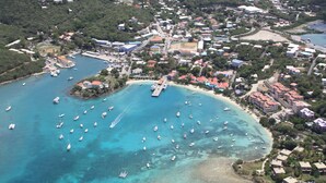 Vue aérienne d’une ville côtière avec un port de plaisance, des bateaux et des immeubles résidentiels.
