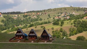 Ein ländliches Dorf mit traditionellen Holzhäusern an einem Hang.