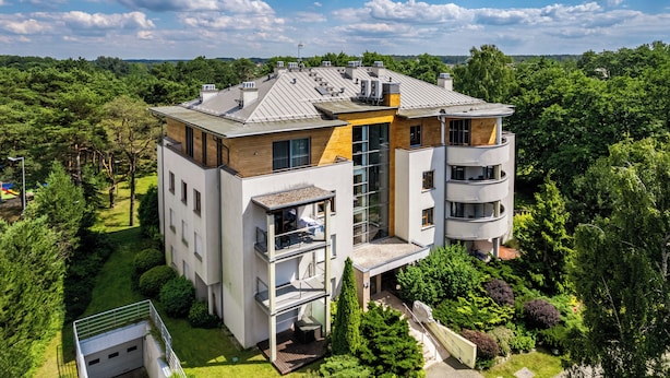 A modern multi-story building with a flat roof, large windows, and a balcony. - Apartamenty Sun&Snow Wczasowa Południowe (Ustka)
