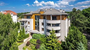 A multi-story residential building with balconies, a central courtyard, and surrounding greenery. - Apartamenty Sun&Snow Wczasowa Południowe (Ustka)