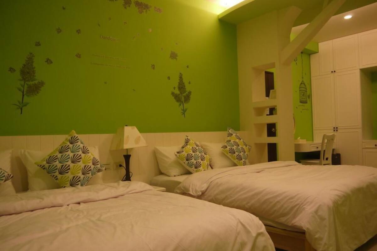 A room with two beds, a desk, and a wardrobe.