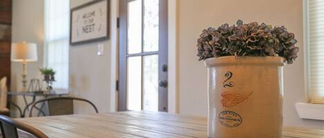 A rustic wooden table with a potted plant in a vintage-style pot.