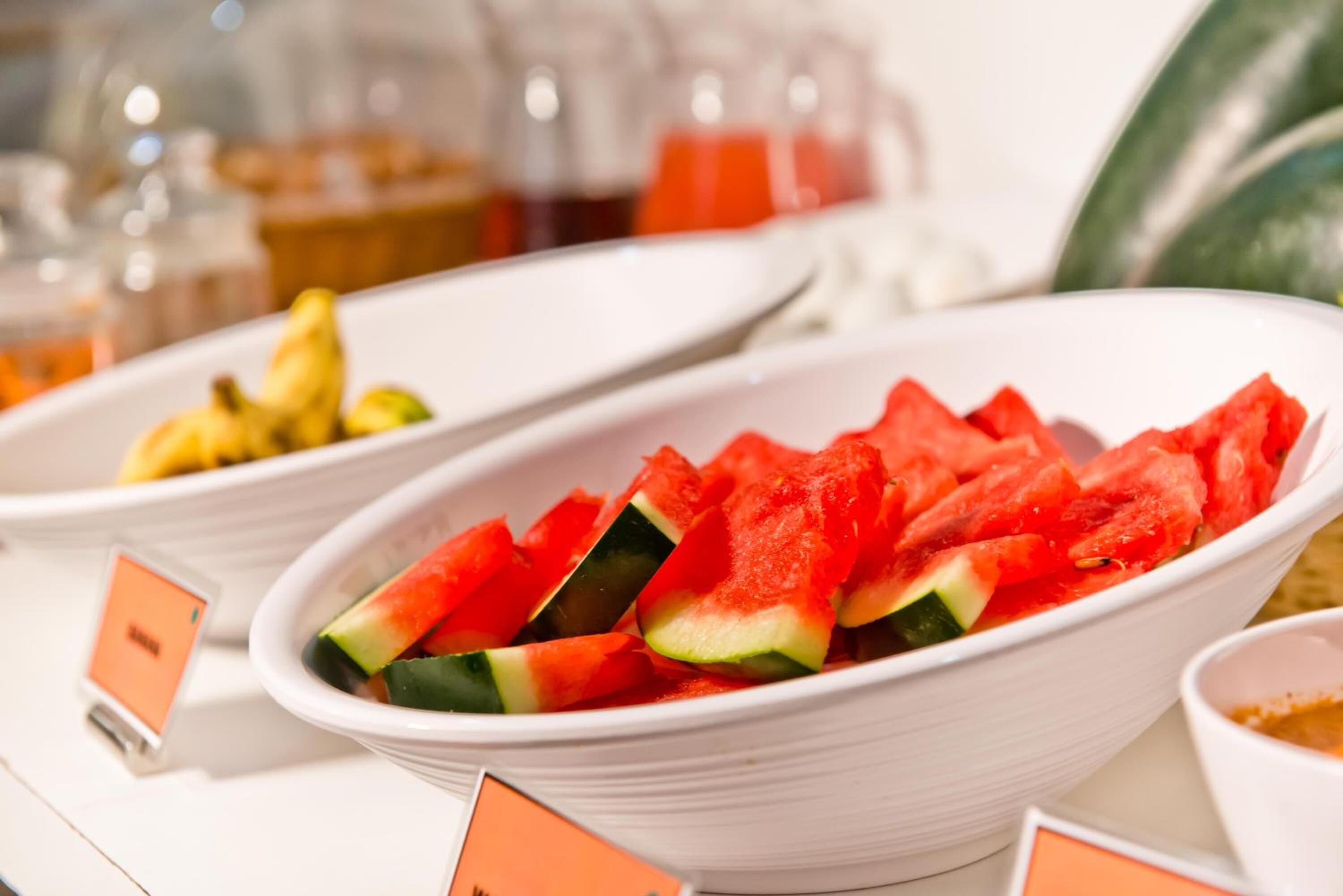 A buffet with watermelon slices and other fruits.