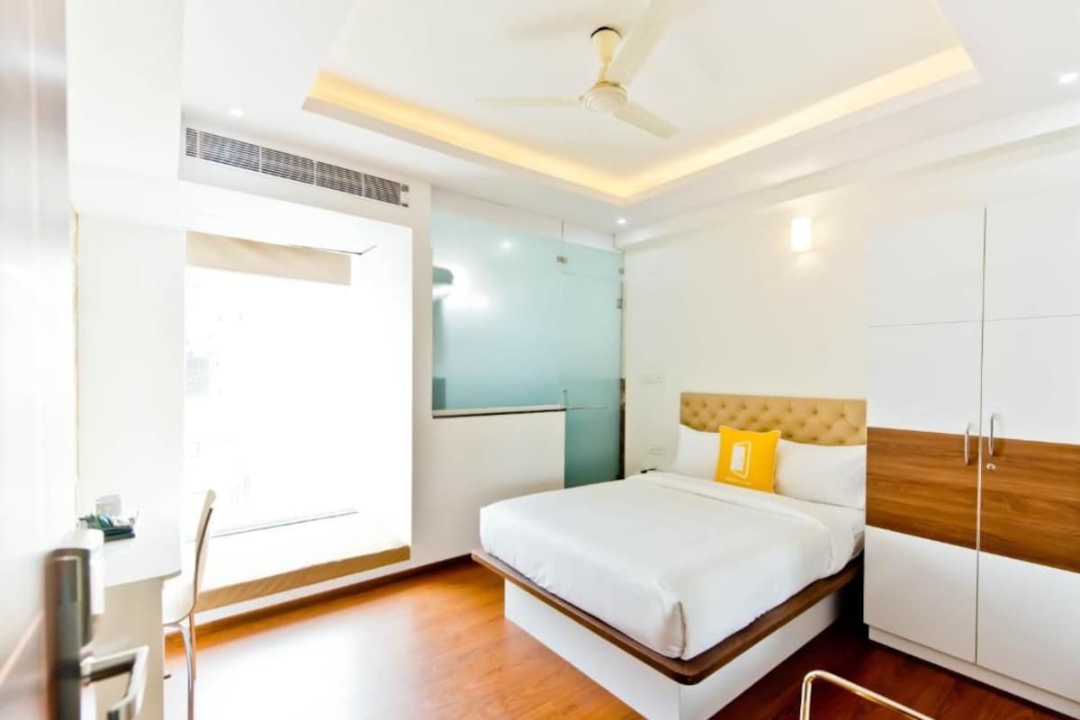 Una habitación de hotel con cama, armario y ventilador de techo.