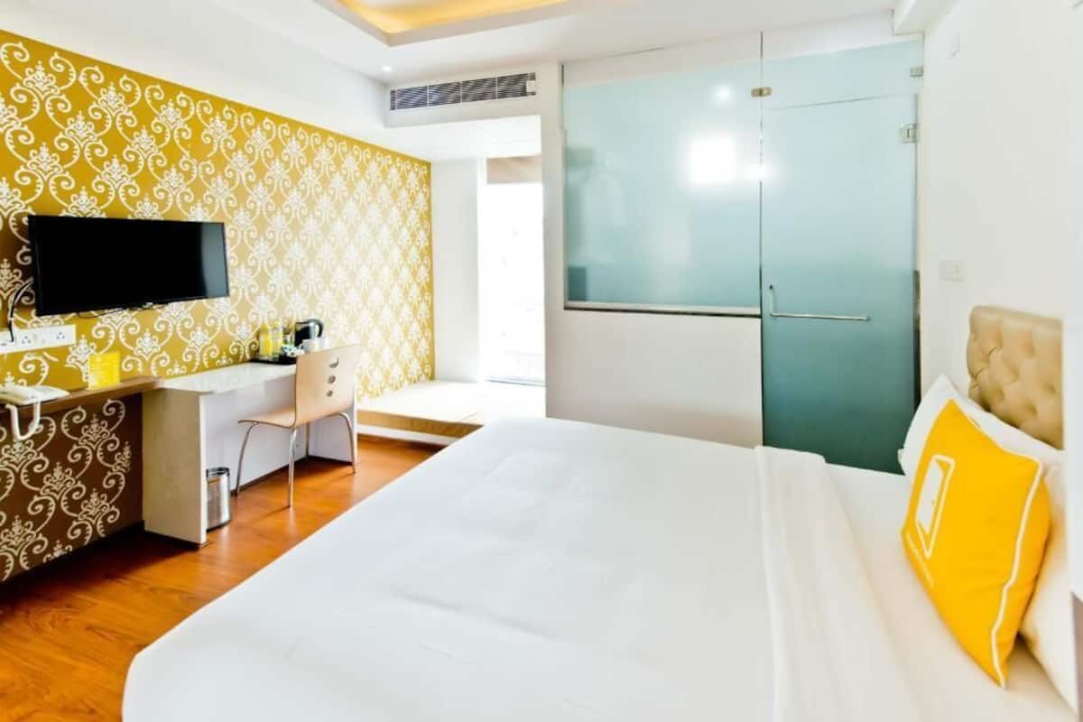 Une chambre d’hôtel équipée d’un lit, d’un bureau, d’une chaise, d’une télévision et d’une armoire.