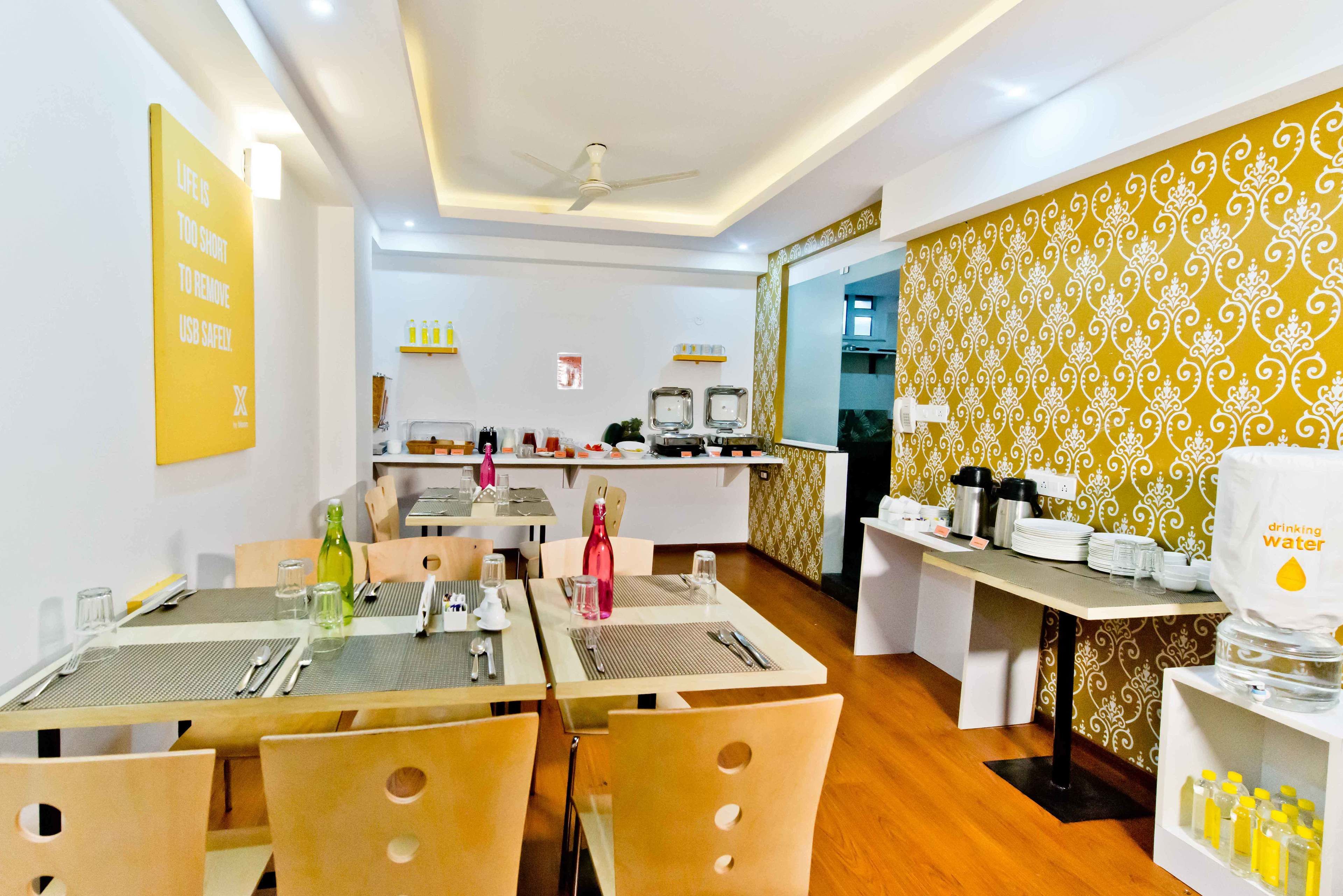 A dining area with tables set for four, a coffee station, and a water dispenser.