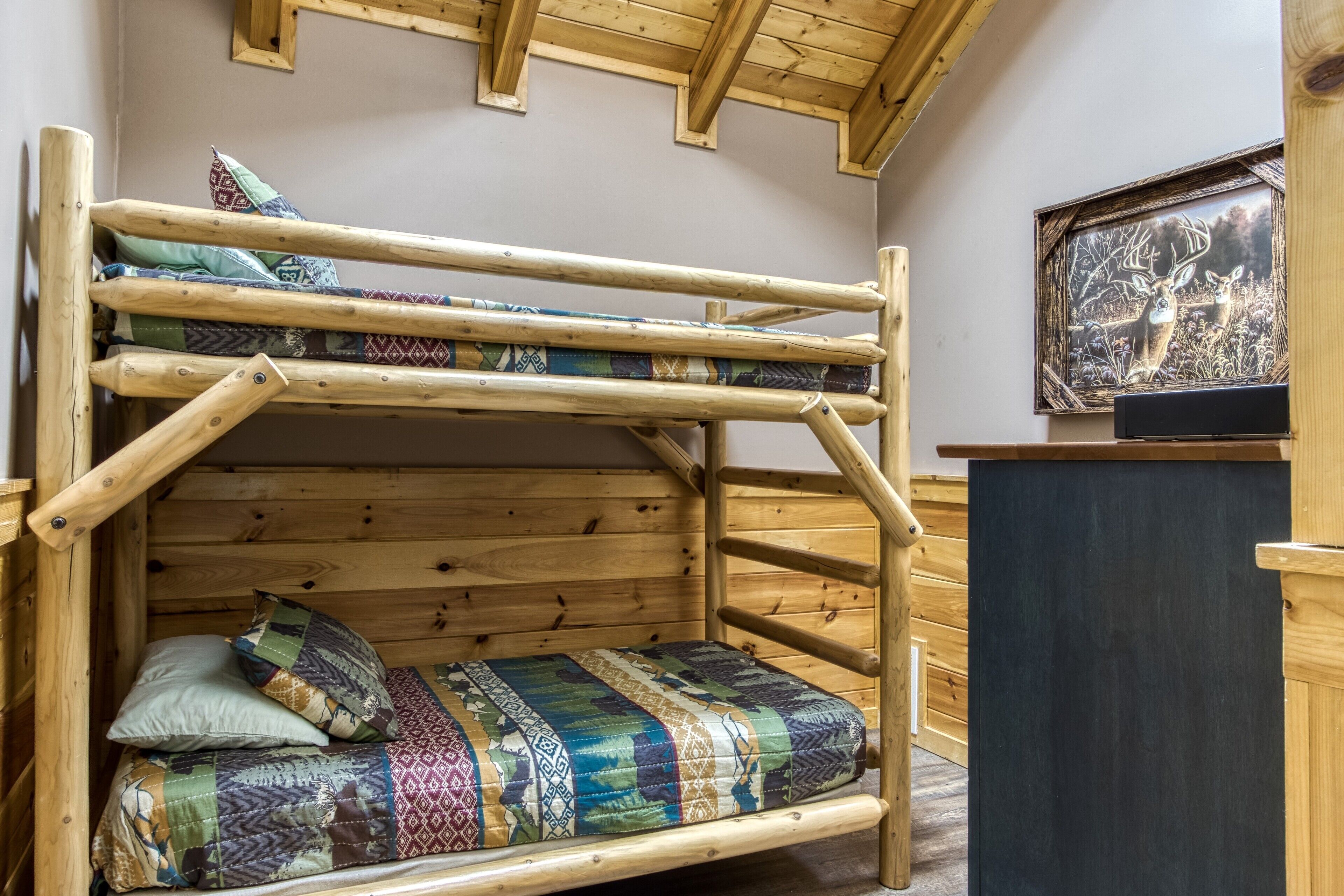 A bunk bed with a wooden frame and patterned bedding.