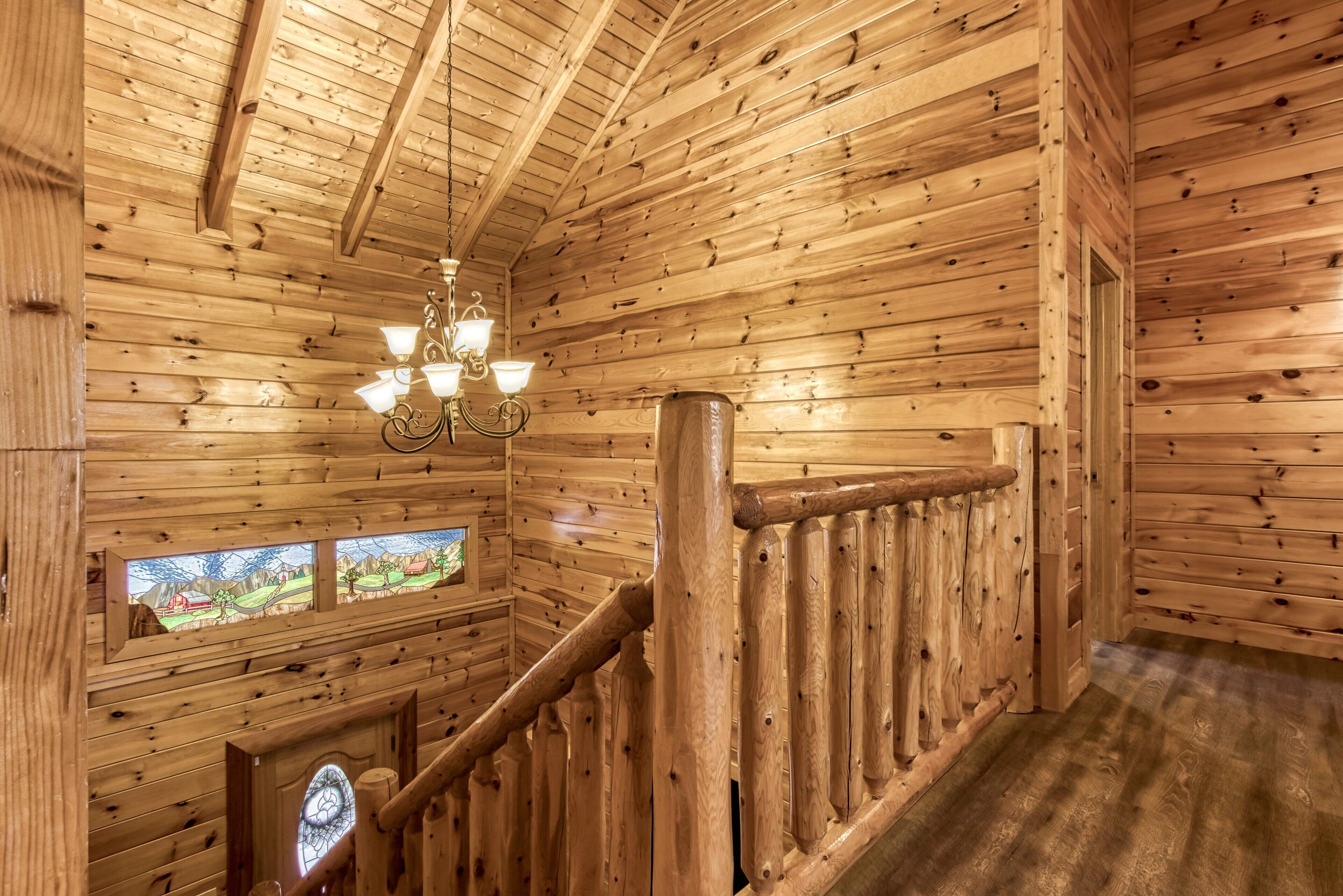 Ein Holzinnenraum mit Treppe, Holzwänden und einer Chandelüster.