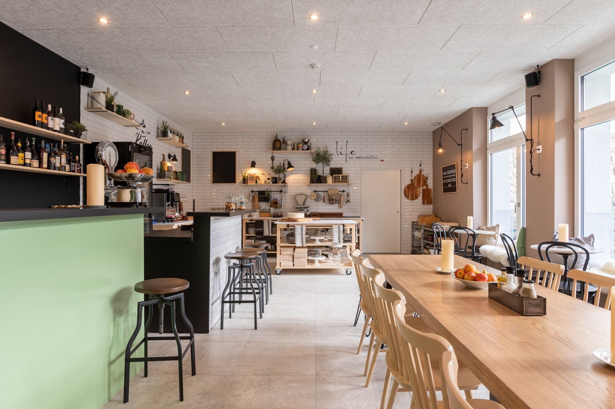 Una cocina moderna con barra, paredes de azulejos blancos y una variedad de utensilios y electrodomésticos.