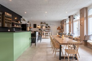 A modern kitchen with a central island, bar area, and seating for dining. - Emma's B&B LUNGERN - Self Check-in Hotel (Lungern)