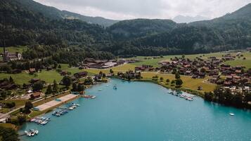 Vista aérea de un pueblo a orillas de un lago con casas, una iglesia y un puerto deportivo.