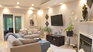 A living room with a sofa, ottoman, and a fireplace. - Home Away From Home,  pet friendly retreat! (Ocean Pines)