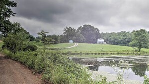 A rural landscape with a pond, a dirt path, and two houses. - Blue Ridge Nature Lovers retreat (Callaway)