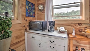 A compact kitchen with a microwave, coffee maker, and a small table with a basket. - Blue Ridge Nature Lovers retreat (Callaway)