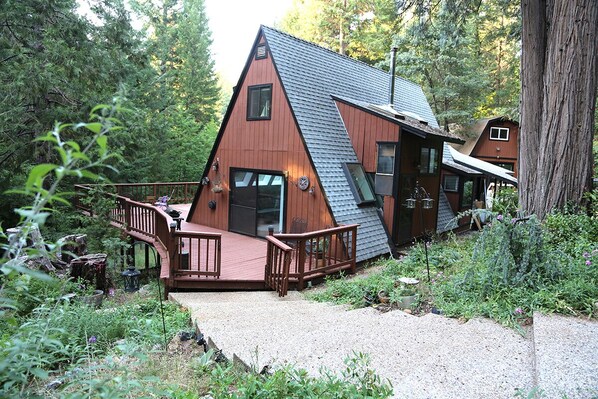 A cabin with a sloped roof, a deck, and a small porch.