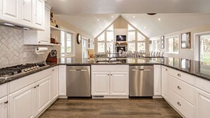 A spacious kitchen with white cabinetry, stainless steel appliances, and a large island.