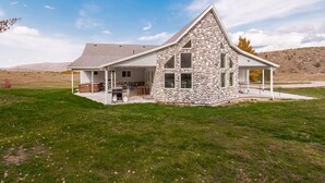 A modern house with a stone facade, a large garage, and a spacious backyard.